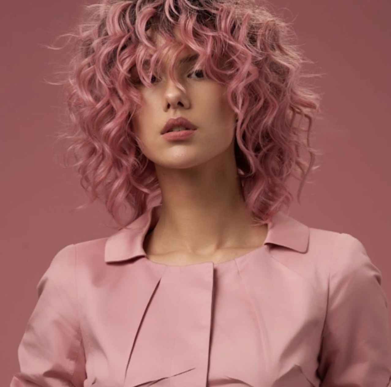 Woman with stylish, pink haircut set on pink background