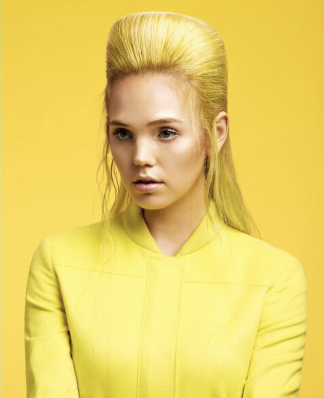 Woman with stylish, yellow haircut set on a yellow background